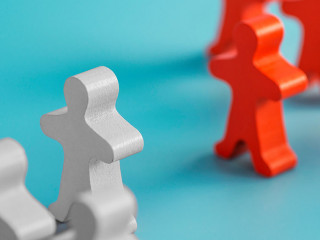 Two groups of wooden figures are standing in front of each other