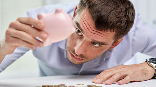 Junger-Mann-leert-Sparschwein-89042723-FO-Syda-Productions