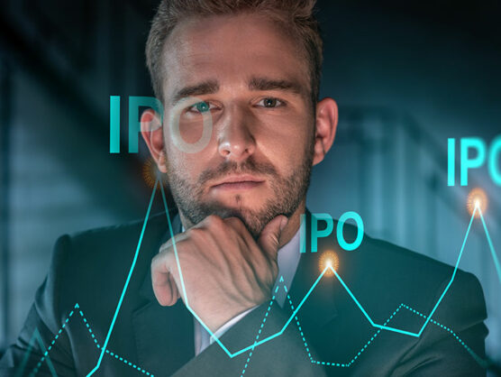 Portrait of handsome businessman in formal suit thinking how to optimize IPO strategy. Financial chart hologram over modern office background. Go public concept. Hand on chin.
