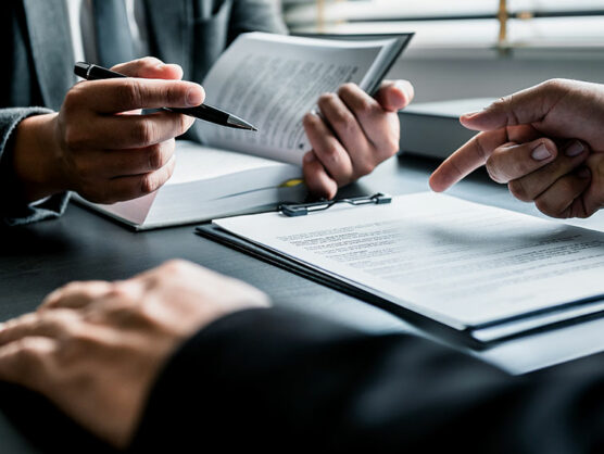 Close up of lawyers discussing contract or business agreement at law firm office,