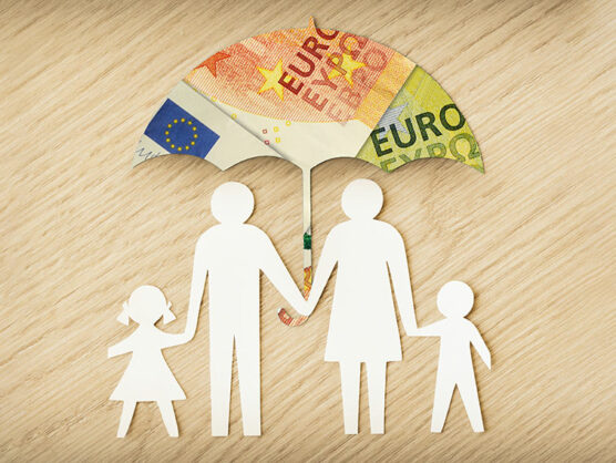 Paper family silhouette with umbrella made of euro banknotes on wooden background - Concept of family financial protection