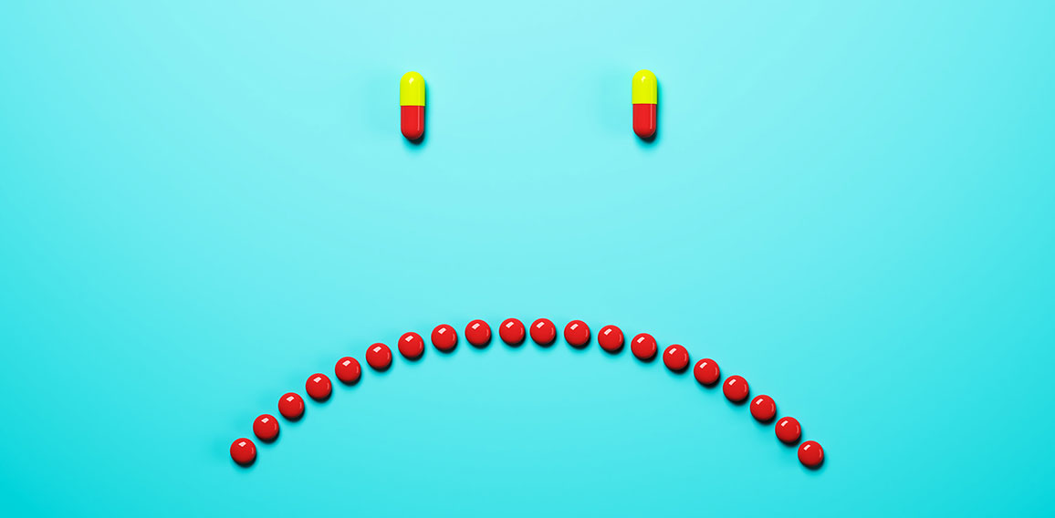 Abstract frowning pills on blue background. Medicine and illness concept. 3D Rendering