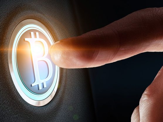 Finger drückt auf Bitcoin-Button