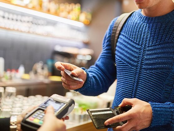 Mann bezahlt mit Kreditkarte in Geschäft