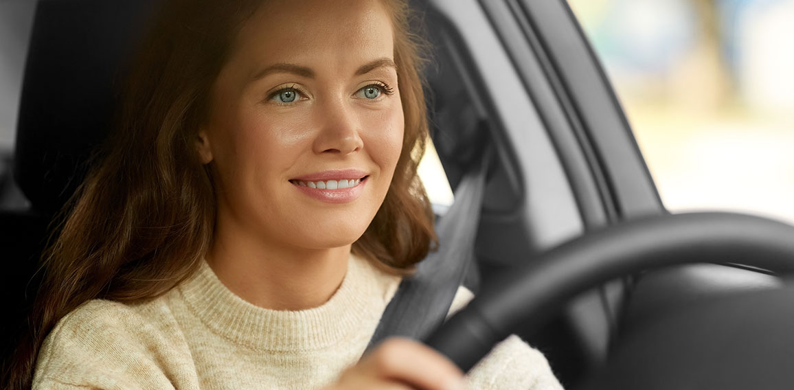 Frau lächelt beim Autofahren