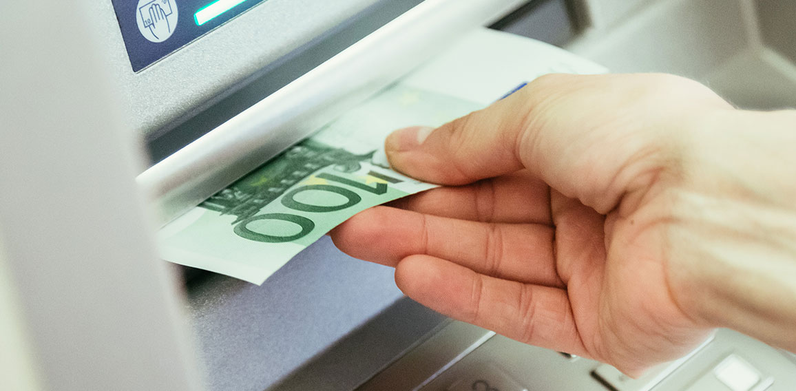 Hand zieht 100-Euro-Schein aus Geldautomat