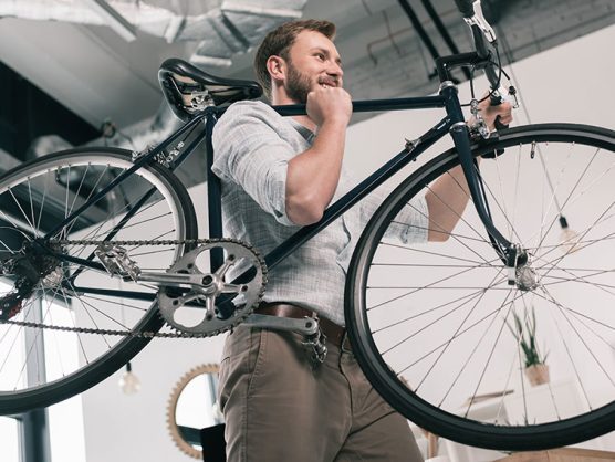 Mann trägt Fahrrad in Büro