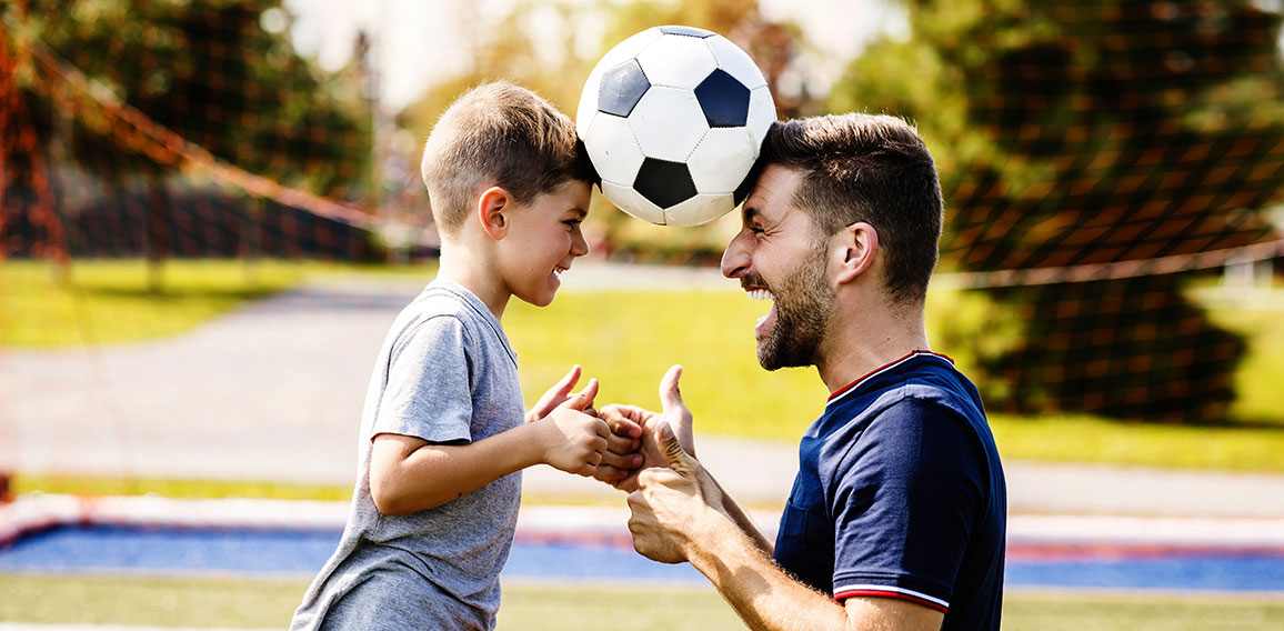 Vater spielt mit Sohn Fußball