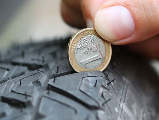 Hand steckt Euro-Münze in Profil