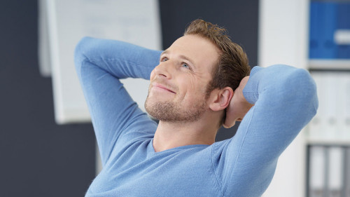 entspannter geschäftsmann verschränkt hände hinter dem kopf