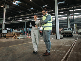 Inspector on tour in large metal industry factory.