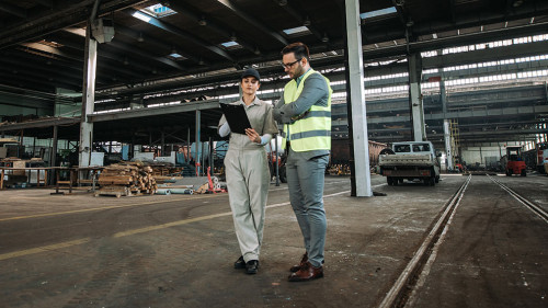 Inspector on tour in large metal industry factory.