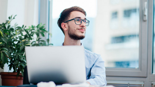 Young businessman in office working on laptop