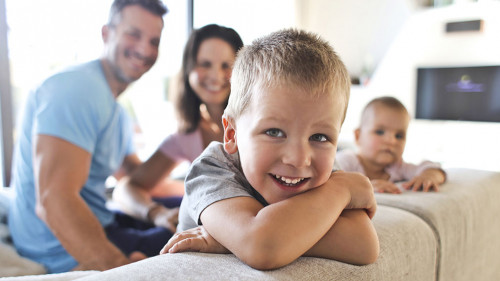 Smiling kids with their parents in the living room