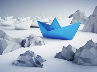 Papierschiffe zwischen Felsen