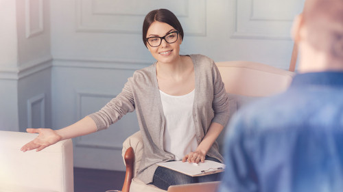 Cheerful school psychologist going to talk with a teen boy