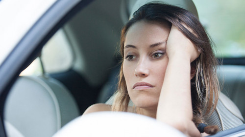Bored woman waiting patiently in her car