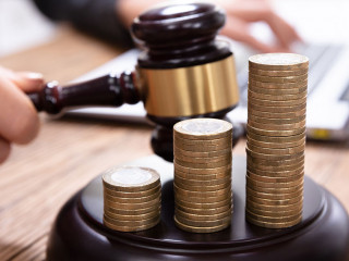 Stack Of Increasing Coins On Gavel At Workplace