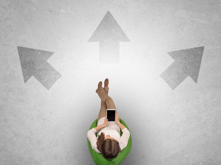 Woman sitting in office with device an her hand