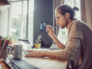 Young freelancer working with laptop at home.
