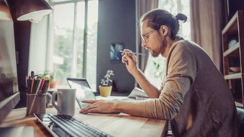 Young freelancer working with laptop at home.