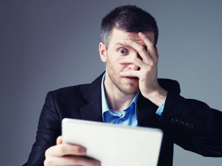 Shocked businessman with digital tablet