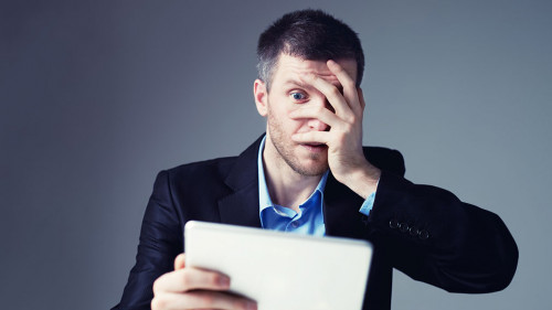 Shocked businessman with digital tablet