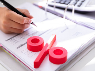 Businessperson's Hand Calculating Bill With Calculator