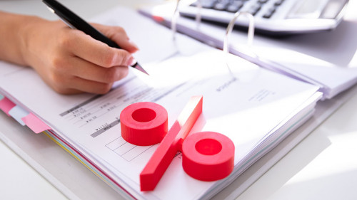 Businessperson's Hand Calculating Bill With Calculator