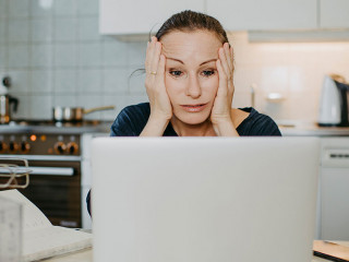 Überforderte Frau beim Home-Office in der Küche