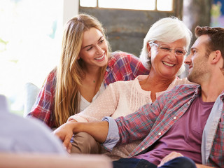 Family With Adult Children Relaxing On Sofa At Home Together