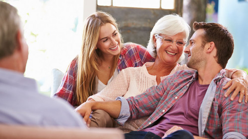 Family With Adult Children Relaxing On Sofa At Home Together
