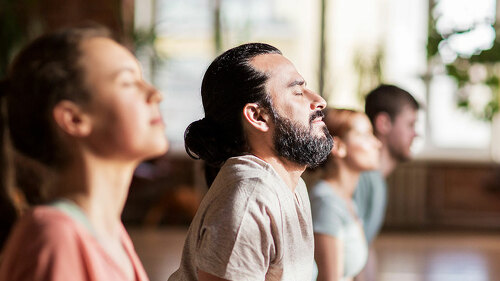 group of people doing yoga dog pose at studio