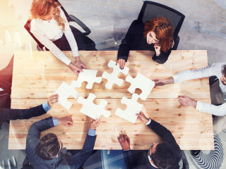 Teamwork of partners. Concept of integration and startup with puzzle pieces and gear overlay. double exposure