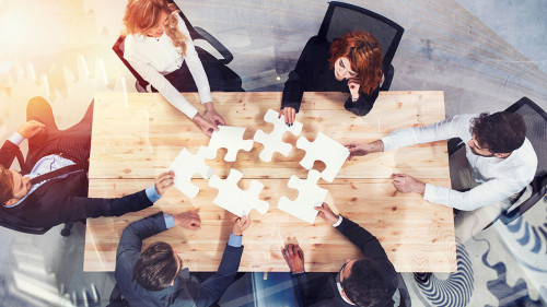 Teamwork of partners. Concept of integration and startup with puzzle pieces and gear overlay. double exposure