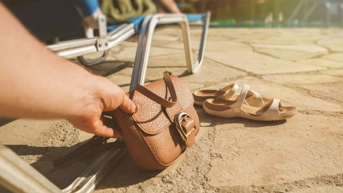 Thief stealing a bag from a woman on vacation.