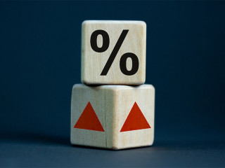 Wooden cubes changes the direction of an arrow symbolizing that the interest rates are going down or vice versa . Business concept. Copy space, beautiful grey background.