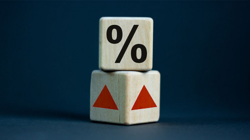 Wooden cubes changes the direction of an arrow symbolizing that the interest rates are going down or vice versa . Business concept. Copy space, beautiful grey background.