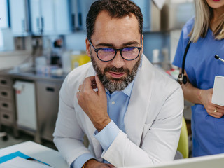 Pharmaceutical sales representative presenting new product to doctors in holding tablet. Presenting new pharmaceutical product, drugs, medication.