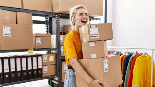Young blonde woman working at small business ecommerce celebrating crazy and amazed for success with open eyes screaming excited.