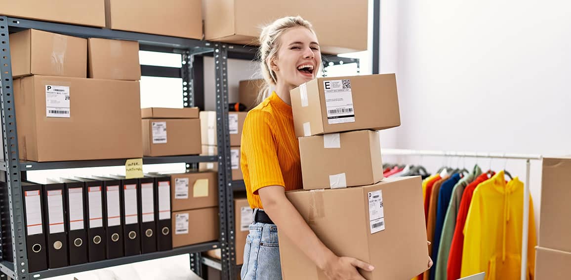 Young blonde woman working at small business ecommerce celebrating crazy and amazed for success with open eyes screaming excited.