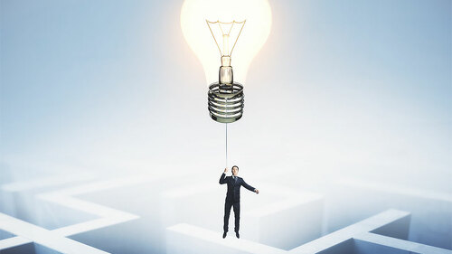 Anzugtraeger-an-Gluehbirne-ueber-Labyrinth-214468907-FO-peshkova