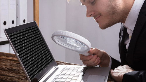 Anzugtraeger-Lupe-Laptop-190689205-FO-Andrey-Popov