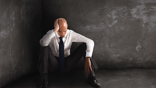 Deprimierter-Anzugtraeger-in-Ecke-150706283-FO-alphaspirit