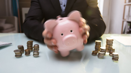 Anzugtraeger-schuettelt-Sparschwein-199508460-FO-Andrey-Popov