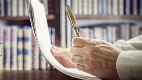 Anzugtraeger-Lupe-Papier-142719046-FO-Brian-Jackson