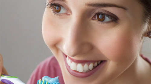 Frau-laecheln-Zahnbuerste-2099474-PB-PourquoiPas