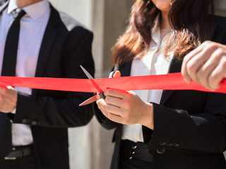 Anzugtraegerin-durchschneidet-rotes-Band-210275878-FO-Andrey-Popov