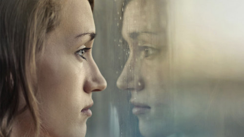 Frau-traurig-Fenster-193542192-FO-olly