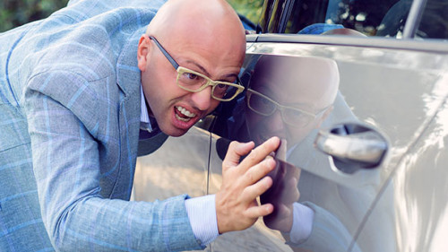 Anzugtraeger-Auto-Kratzer-197289174-AS-hbrh